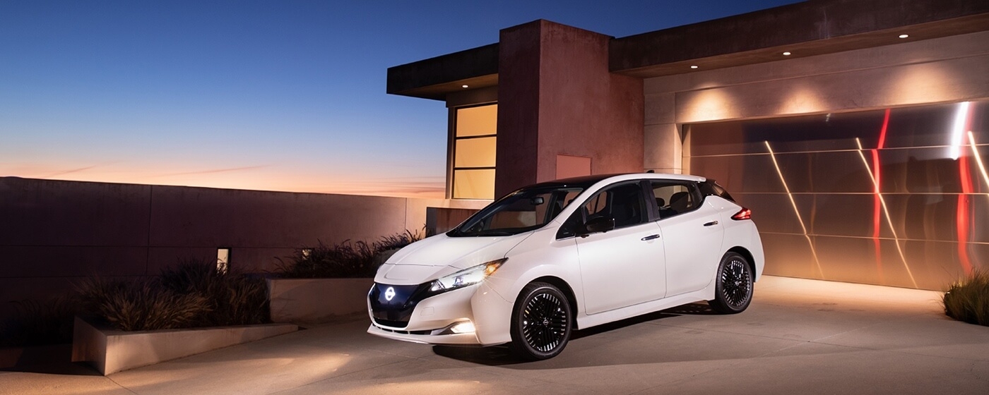 La Nissan Leaf 2025 stationnée dans la cours d'une maison.