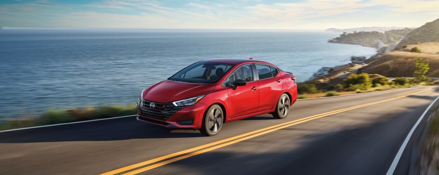 La Nissan Versa 2025 sur la route au bord de la mer.