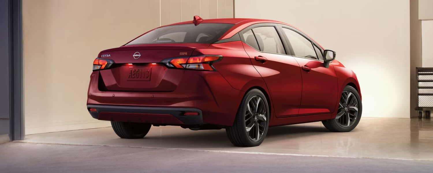 Vue 3/4 arrière de la Nissan Versa 2025 garée dans le garage d'une maison.